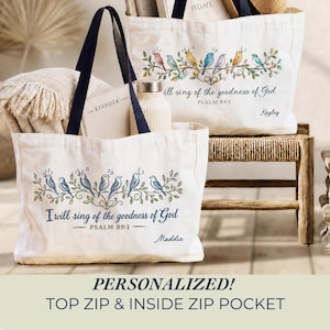 May include: Two off-white canvas tote bags with dark navy handles, each featuring a printed illustration of colorful birds perched on a leafy branch. The text reads, "I will sing of the goodness of God, PSALM 89:1," with personalized names "Maddie" and "Kayley."