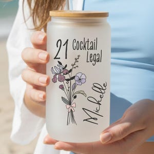21st birthday glass with the number 21 and says cocktail legal colored birthflower personalized with name February birth flower shown Iris on frosted glass tumbler