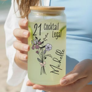 21st birthday glass with the number 21 and says cocktail legal colored birthflower personalized with name February birth flower shown Iris on frosted glass tumbler