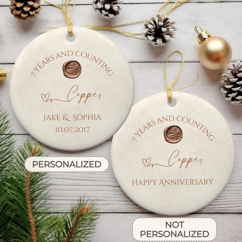 May include: Two white ceramic ornaments with a copper anniversary theme. One ornament is personalized with the names Jake & Sophia and the date 10.07.2017. The other ornament says "7 Years and Counting Copper Happy Anniversary".
