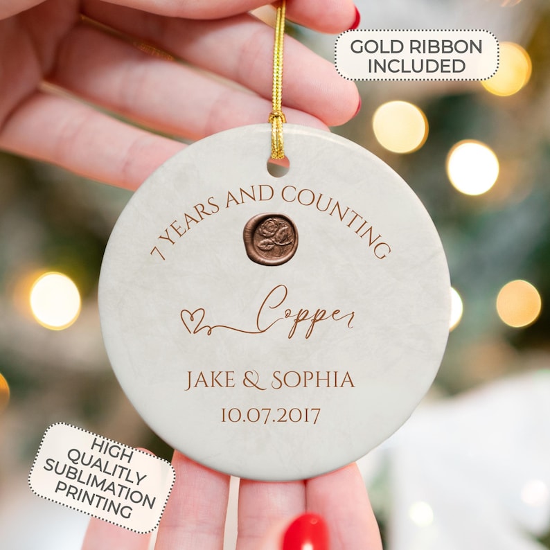 May include: White round ceramic ornament with the text "7 Years and Counting Copper" in copper lettering. The ornament also includes the names "Jake & Sophia" and the date "10.07.2017".