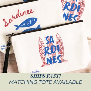 Sardines Mediterranean sailorcore personalized Zipper close canvas sardines makeup bag pencil pouch with bold blue and red sardine print and optional personalized name in script on cream coastal fabric. Sailorcore sardinecore and Mediterranean market girl aesthetic perfect for storing makeup pens and travel essentials and designed to coordinate with the large coastal sardines tote bag sold separately.