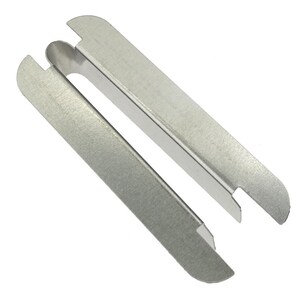 May include: A silver metal clip with a rounded shape and a narrow opening in the center. The clip is designed to hold two pieces of paper or fabric together.