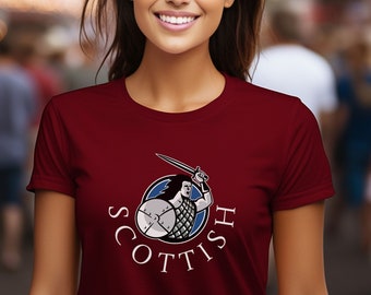 May include: A maroon t-shirt with a white graphic of a Scottish warrior holding a sword and shield. The graphic is surrounded by the word "SCOTTISH" in white.