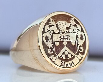 May include: A gold signet ring featuring a crest and the inscription "Hunt" on the face.