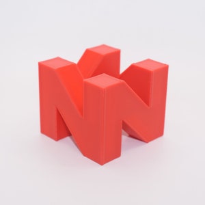 May include: Two red 3D printed letters forming the letter "N".
