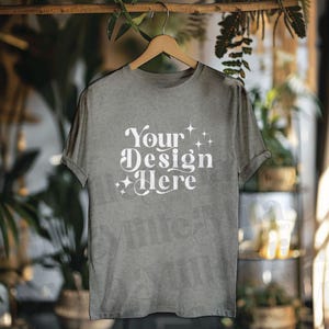 May include: A gray t-shirt with the text "Your Design Here" in white lettering with a retro font and small white stars.