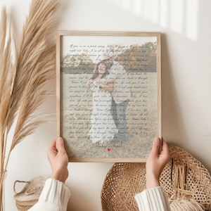 May include: A framed print with a light wood frame is held by two hands. The print features a photograph overlaid with handwritten text. The text includes the date 10.19.2024 and the names Lindsay & Patrick, with a small red heart.