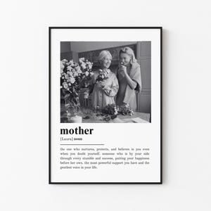 May include: Black and white framed print featuring a photograph of two women holding flowers. The word "mother" is displayed in a bold font, along with a definition. A thoughtful gift for Mother's Day or a special occasion.