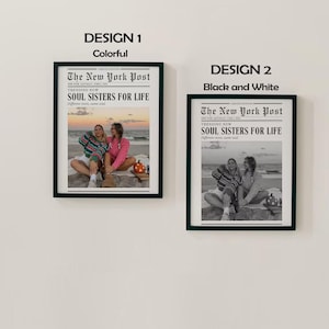 May include: Two framed prints, one colorful and one black and white, hang on a white wall. The prints feature a newspaper-style design with the text "The New York Post" and "SOUL SISTERS FOR LIFE". The colorful print shows two people on a beach.