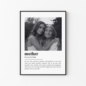 May include: Black and white framed print featuring a photograph of two women embracing. The word "mother" is printed below the image, along with a definition. The frame is black, and the background is white.