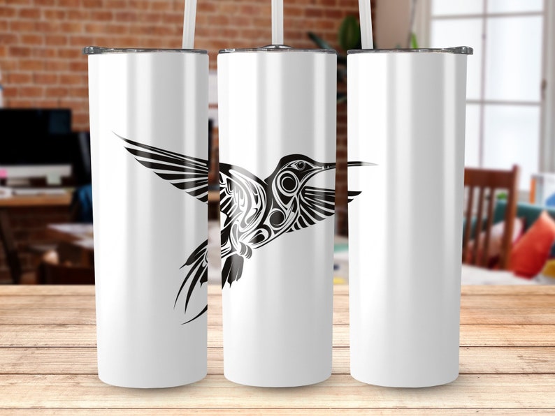 Puede incluir: Tres vasos de acero inoxidable blanco con un dise&ntilde;o de colibr&iacute; en blanco y negro. El colibr&iacute; est&aacute; estilizado con formas geom&eacute;tricas y mira hacia la derecha.