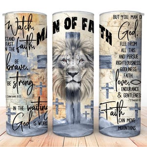 Puede incluir: Un juego de tres vasos de acero inoxidable con temática religiosa. Cada vaso presenta una cara de león, cruces y texto inspirador como "Hombre de Fe" y "Dios". El diseño está sobre un fondo texturizado y desgastado.