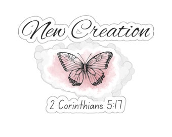 May include: A white sticker with a black butterfly illustration on a pink watercolour background. The text "New Creation" is above the butterfly and "2 Corinthians 5:17" is below.