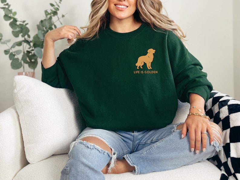 May include: A dark green sweatshirt with a golden retriever silhouette and the text "Life is Golden" on the front.
