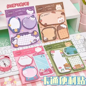 May include: A set of colourful sticky notes featuring cute cartoon characters and whimsical designs. The notes are organised into three packs, each with a different theme: "Wonderful Life", "So Sweet!" and "Be Happy".