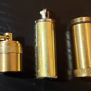 以下が含まれることがあります： キーリング付き、芯付き、ねじ付きの蓋が付いた3つの真鍮製の容器