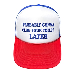 May include: A red, white, and blue trucker hat with the text "PROBABLY GONNA CLOG YOUR TOILET LATER" in blue. The hat has a red brim, a white front panel, and a blue mesh back.