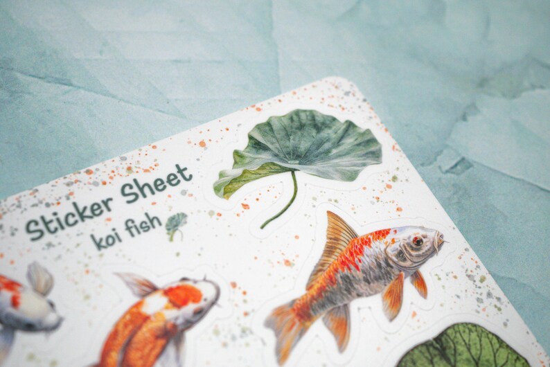 May include: A sticker sheet with the text "Sticker Sheet koi fish" and illustrations of koi fish and a green lotus leaf.