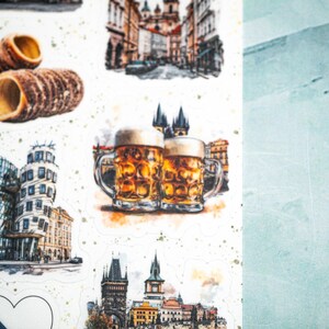 May include: Watercolor illustrations of Czech Republic landmarks and food items. The images include Trdeln&iacute;k pastries, beer steins, and architectural scenes of Prague. The stickers have a white background with gold speckles and a light blue background.