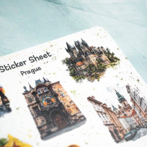 May include: A sticker sheet featuring watercolor illustrations of Prague landmarks. The sheet includes images of the Prague Castle, the Astronomical Clock, and other architectural details. The text "Sticker Sheet Prague" is printed at the top.