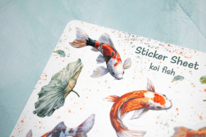 May include: Sticker sheet with illustrations of koi fish and lotus leaves. The sheet is white with a speckled background and the text "Sticker Sheet koi fish" at the top.