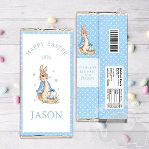 May include: A blue and white chocolate bar wrapper with a bunny rabbit holding a basket of eggs. The wrapper says "Happy Easter 2025" and "With love Mummy and Daddy". The name "Jason" is printed at the bottom of the wrapper.