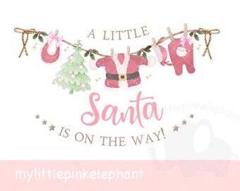 May include: A watercolor illustration with the text "A Little Santa is on the Way!" features baby clothes and a Christmas tree hanging on a clothesline. The baby clothes are pink and white, with a Santa suit design.