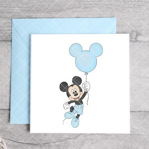 May include: A light blue envelope and a white card featuring a cartoon illustration of Mickey Mouse holding a blue balloon. Mickey Mouse is wearing blue shorts and shoes. The card is perfect for a birthday or baby shower.