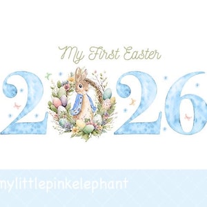 Könnte beinhalten: Aquarell-Design mit dem Text "My First Easter" über der Zahl "2026" in Hellblau. Ein Hase mit blauem Jackett ist von einem Kranz aus Blumen und Ostereiern umgeben. Der Hintergrund ist weiß.