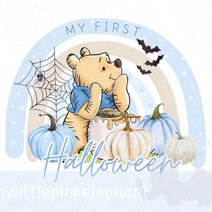 Puede incluir: Un arcoíris azul claro y marrón con el texto "My First Halloween" en fuente marrón. Un oso de peluche Winnie the Pooh de dibujos animados está sentado frente al arcoíris con una camisa azul y una calabaza delante de él. Hay tres calabazas delante del oso, una azul claro, una blanca y una crema.