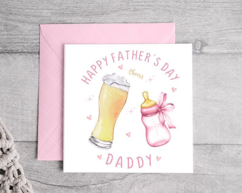 May include: A white card with pink text that reads "Happy Father's Day Daddy" with a glass of beer and a baby bottle with a pink bow. The text "Cheers" is written in pink.