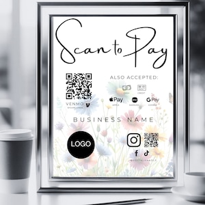 May include: A sign with a floral background and the text "Scan to Pay". The sign also includes a QR code, a Venmo logo, and logos for Apple Pay, Samsung Pay, and Google Pay. The text "BUSINESS NAME" is also included on the sign.