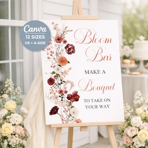 May include: A white rectangular sign on a wooden easel featuring a floral arrangement of red, orange, and cream flowers on the left side. The text reads Bloom Bar, MAKE A BOUQUET, TO TAKE ON YOUR WAY. A circular badge states Canva 12 SIZES US + A-SIZE.