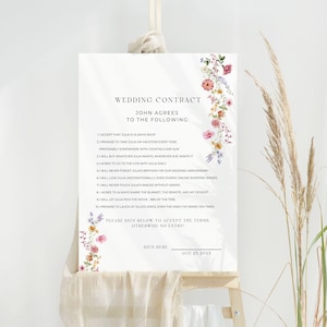 May include: A white wedding contract sign with floral decorations. The text details agreements, with space for a signature and date. The sign is displayed on a wooden stand. The date on the sign is August 25, 20XX.