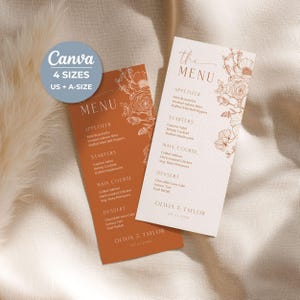 May include: Two vertical menu cards featuring floral line art. One card is terracotta with white text, the other is cream with terracotta text. Both list appetizers, starters, main courses, and desserts, with the names Olivia & Taylor at the bottom.