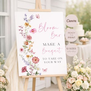 May include: A white sign on a wooden easel with the words "Bloom Bar" and "Make a Bouquet to Take on Your Way" in pink script. The sign is decorated with watercolor flowers and butterflies. The sign is ready to print in 12 sizes.