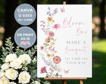 May include: A white rectangular sign on a wooden easel featuring a vertical floral arrangement of pink, yellow, and purple watercolour flowers and butterflies. The text reads Bloom Bar, MAKE A BOUQUET TO TAKE ON YOUR WAY in pink and black script and serif fonts.