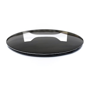 May include: A black, oval-shaped emblem with a white, stylized letter 'I' in the center. The emblem has a glossy finish and a thin, silver border, set against a white background.