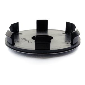 Peut inclure: Un enjoliveur central de moyeu en plastique noir avec un design circulaire. Le capuchon comporte une série de languettes rectangulaires sur le bord et un petit trou au centre. La surface a une finition brillante.