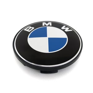 May include: A black and silver BMW wheel center cap. The cap features the BMW logo, a blue and white quadrant design, and the letters "BMW" in white. The cap is round and has a silver trim.