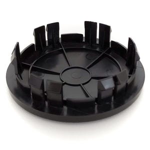 May include: Black plastic wheel center cap with a six-spoke design. The cap has a smooth, rounded surface and a slightly raised edge.