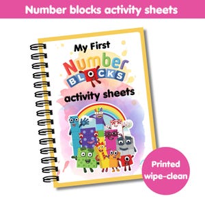 May include: A spiral-bound activity book with the title "My First Number Blocks activity sheets." The cover features colorful cartoon number block characters and a rainbow. A pink circle with the text "Printed wipe-clean" is in the lower right corner.