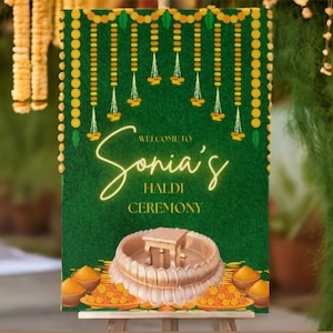 May include: A green welcome sign with yellow floral decorations and the text "Welcome to Sonia's Haldi Ceremony".
