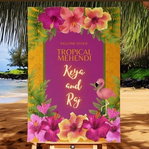 Puede incluir: Un cartel de bienvenida para una boda o evento con temática tropical. El cartel es rosa y dorado con un flamenco y flores de hibisco. El texto en el cartel dice "Bienvenido a nuestro Mehendi Tropical Keya y Raj".