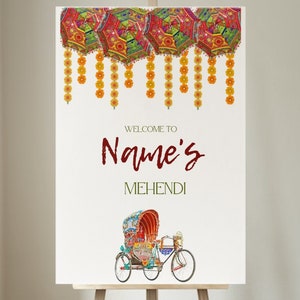 May include: A white sign with the text "Welcome to Name's Mehendi" in maroon and green lettering. The sign is decorated with colourful hanging lanterns and yellow flower garlands. A colourful rickshaw is pictured at the bottom of the sign.