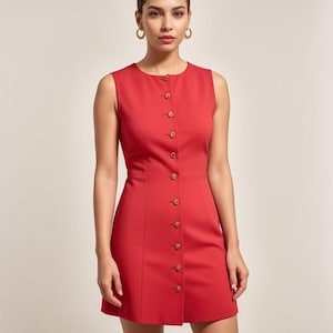 May include: A sleeveless red dress with a button-up front and a fitted silhouette.