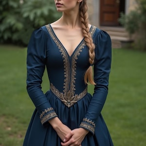 Puede incluir: Una mujer con un vestido largo de color azul oscuro con bordados dorados. El vestido tiene un escote en V y mangas largas. La mujer lleva el pelo en una trenza.