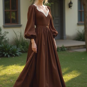 May include: A brown maxi dress with a lace neckline and long sleeves. The dress has a fitted bodice and a flowing skirt. The dress is cinched at the waist with a brown belt.