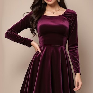Könnte beinhalten: Ein kurzes, burgunderfarbenes Samtkleid mit Rundhalsausschnitt und langen Ärmeln. Das Kleid hat einen figurbetonten Oberteil und einen ausgestellten Rock.